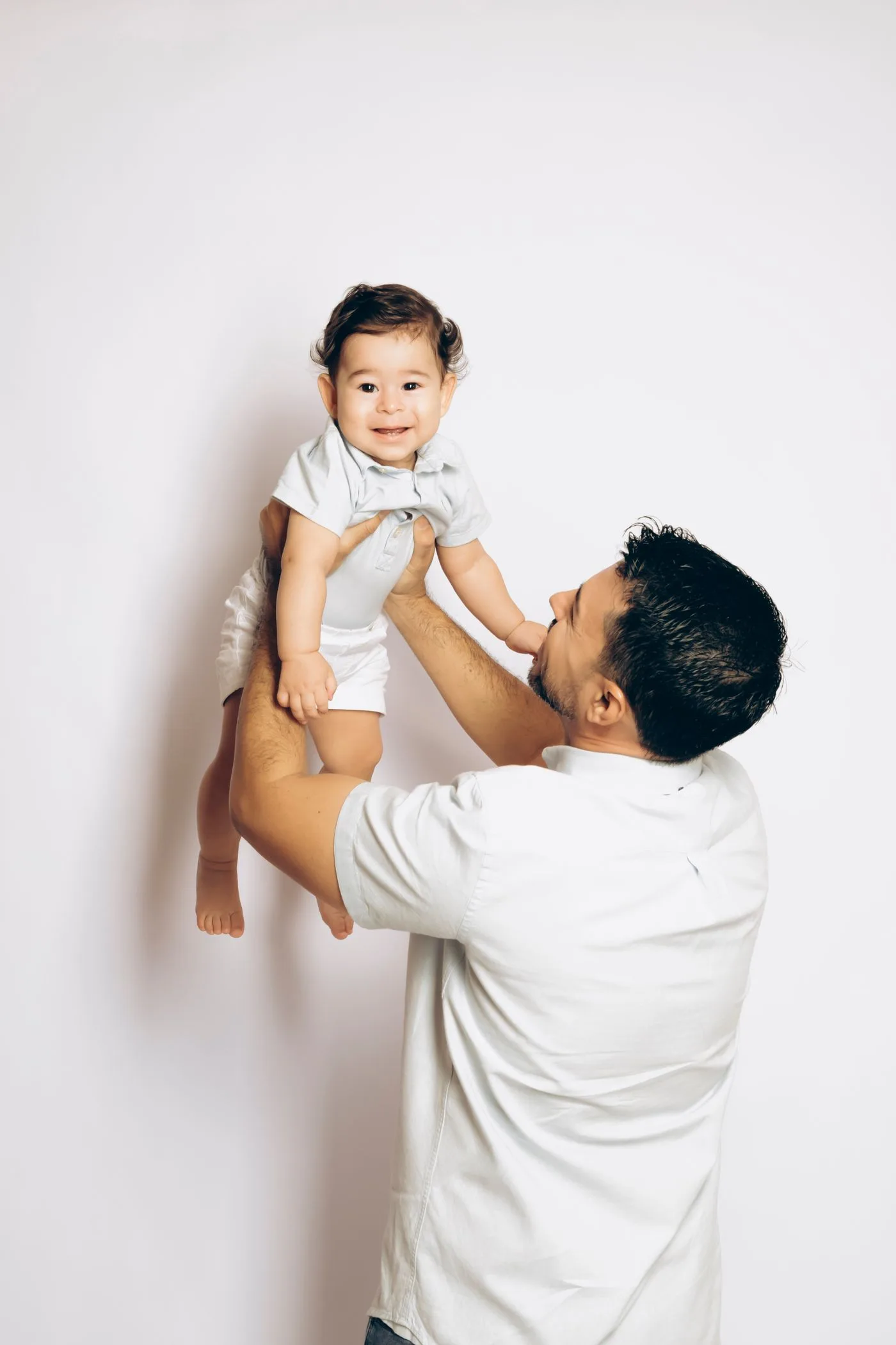 Ein Mann hält sein Baby vor sich