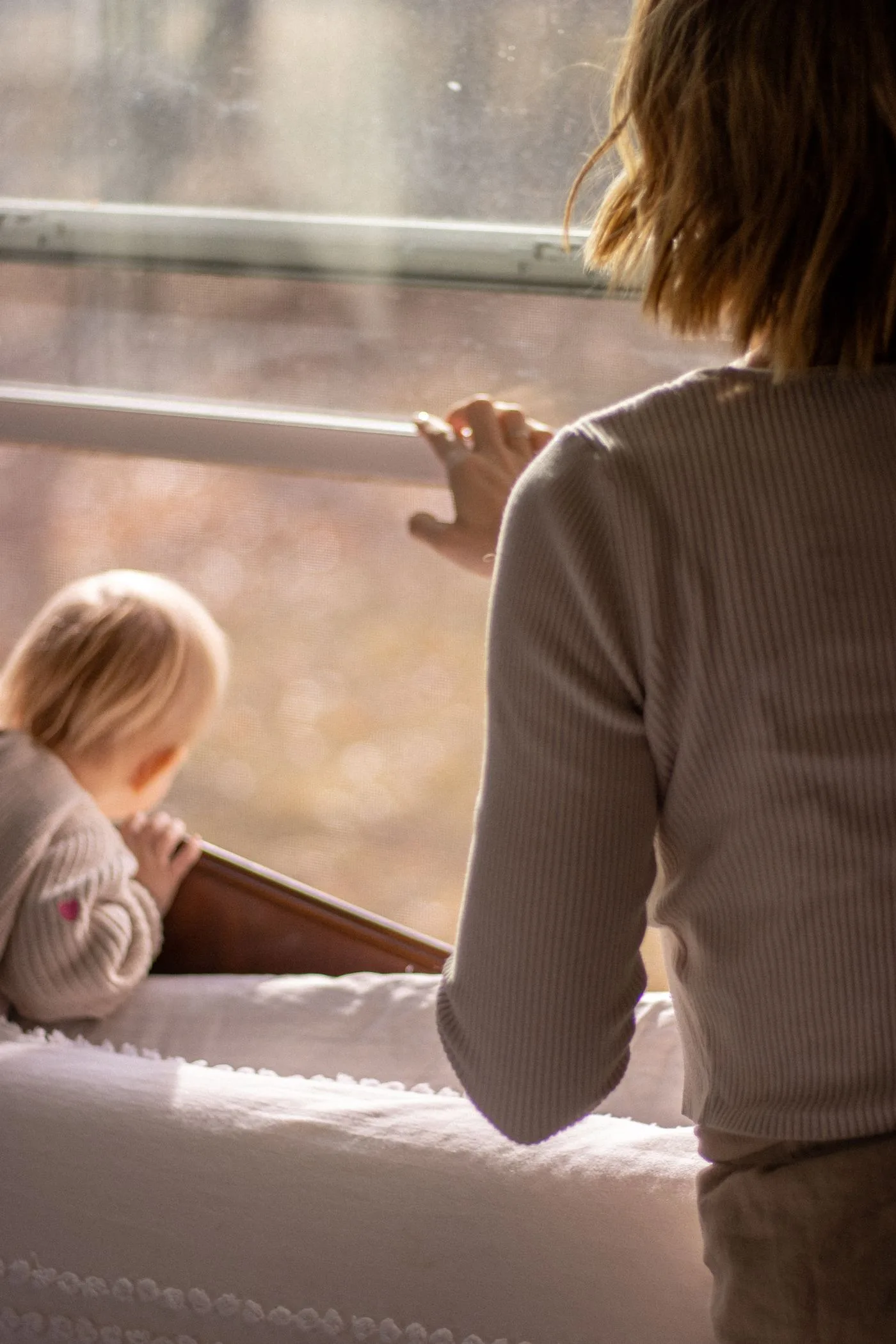 Eine Frau mit Baby am Fenster