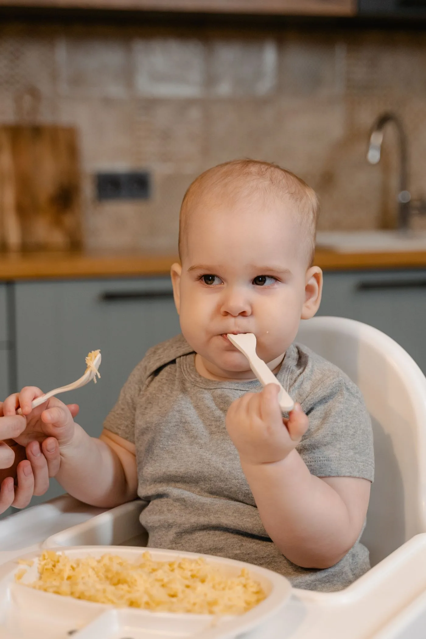 Ein Baby sitzt beim Essen im Hochstuhl
